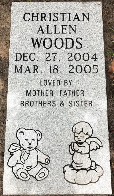 gray granite infant headstone with a teddy bear and praying angel